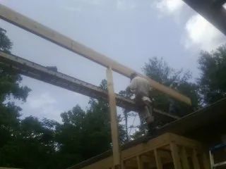 Carpenter setting a ridge beam over a new addition frame — Ice Dam Removal by Roofing Brothers in Braceville