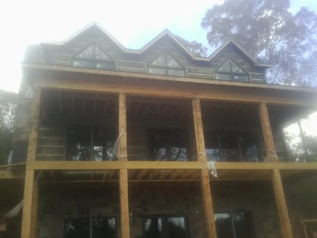 Dormers and porch framing on a large log home under construction — Roof Coating work by our crew in Braceville